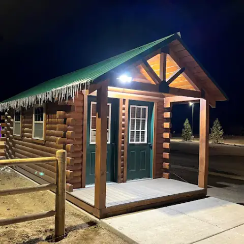 Log camping cabin lit up at night at the campground