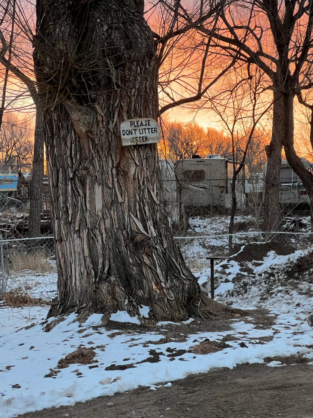 Fiery Colorado sunset over the creek and RVs at the campground